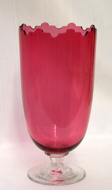 A Cranberry glass celery vase with uncommon cutting to the top